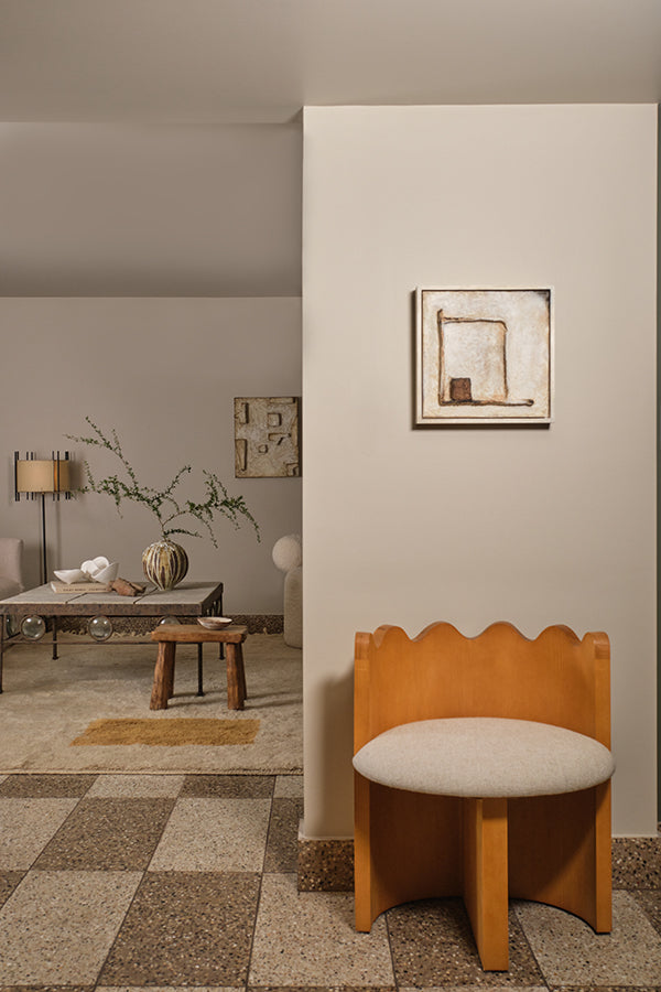 Neutral brown colored interior with brown checkered terrazzo flooring and a carpeted living room in the background.