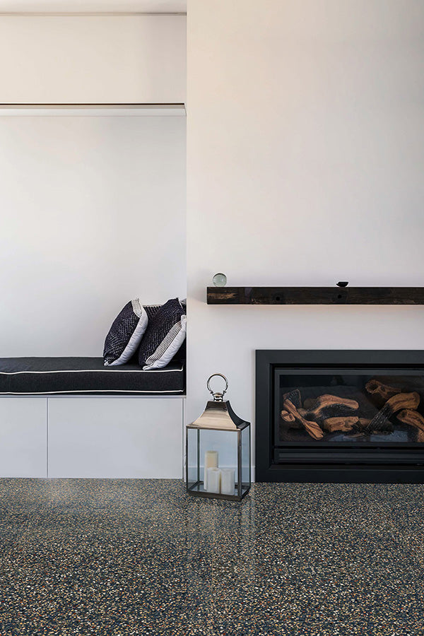 Open white painted living room area with charcoal terrazzo tile flooring and a fireplace with a wooden mantel.