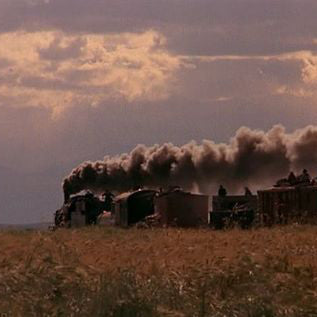 a film still of a train moving through a field