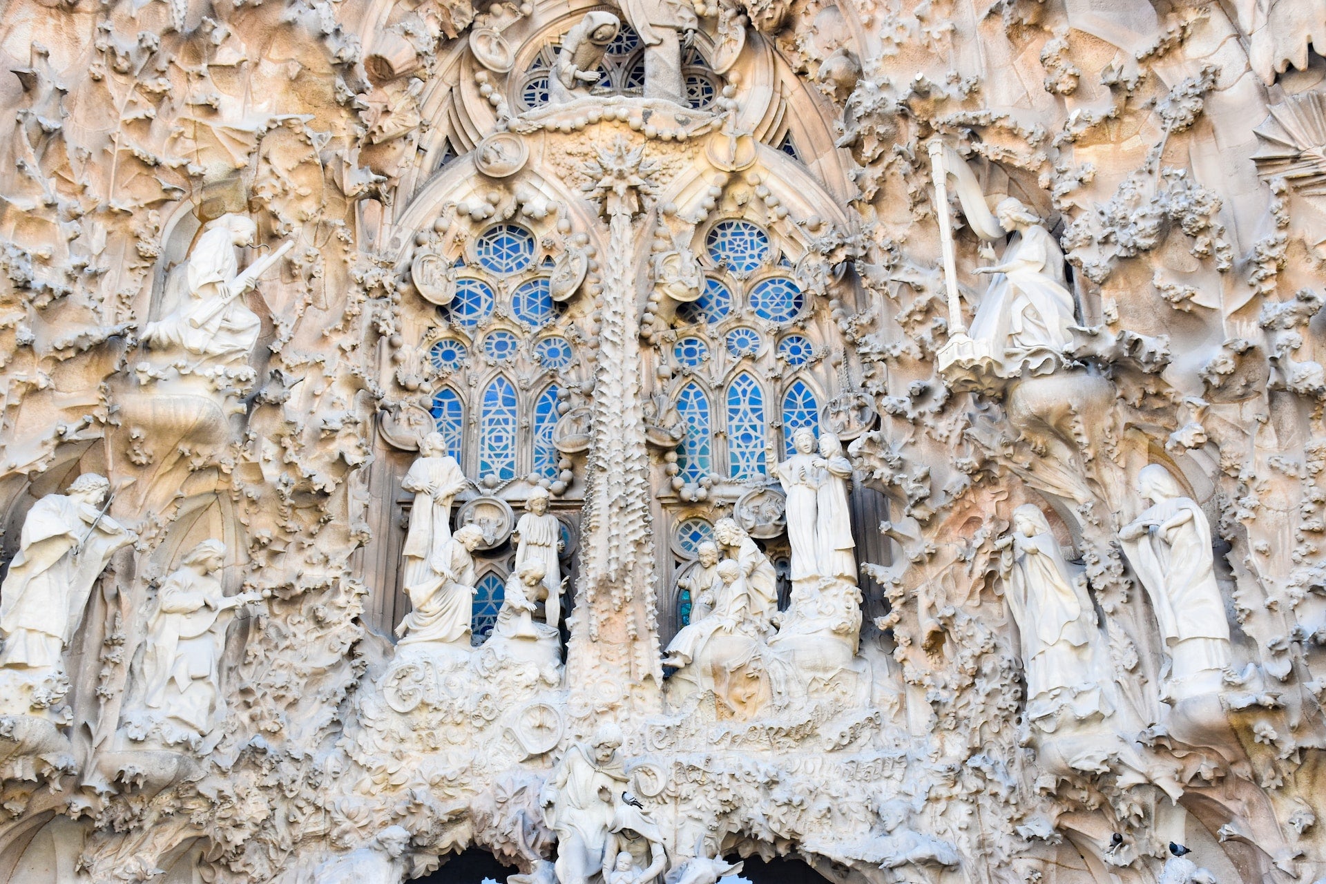 the elaborate facade of the sagrada familia basillica, with sculptures and stained glass windows.