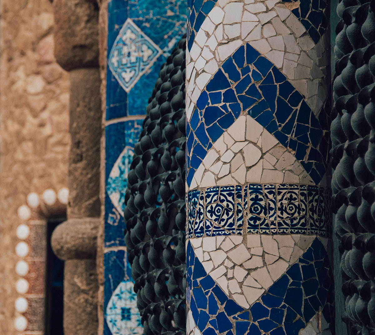 Closeup photo of blue and white mosaic tile at Park Guell by Antoni Gaudí.