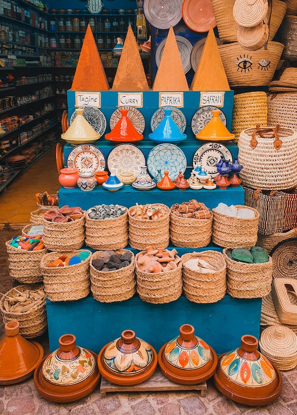 moroccan market display of spices, tagines, and baskets