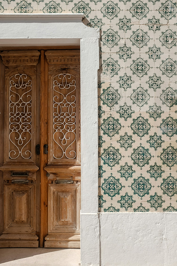 A wood door and a green and cream azulejo wall.