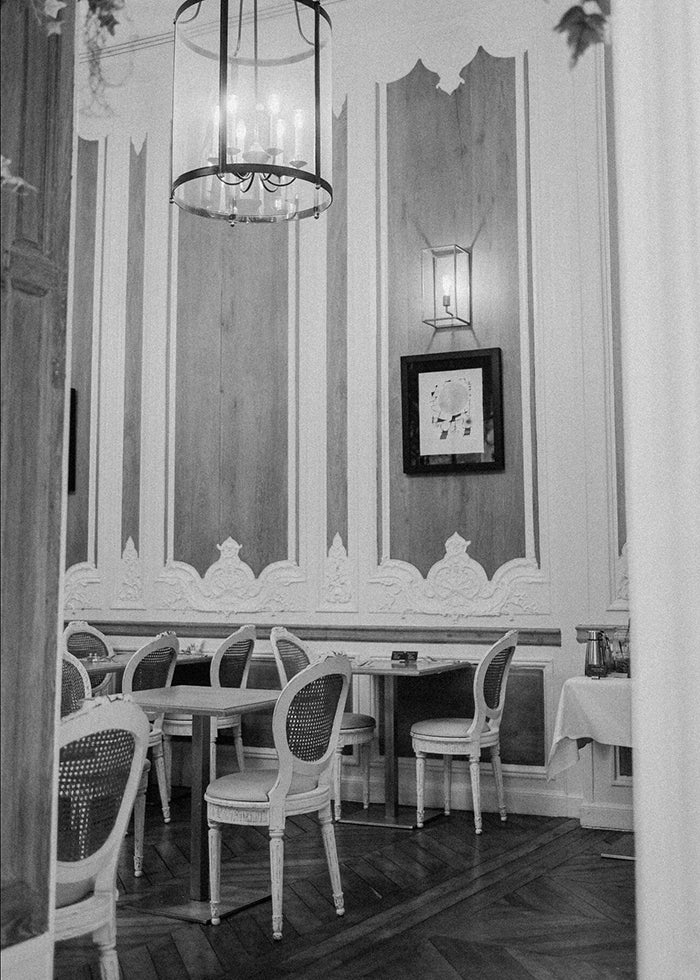 Black and white photo of a dining room in a classic Parisian hotel.