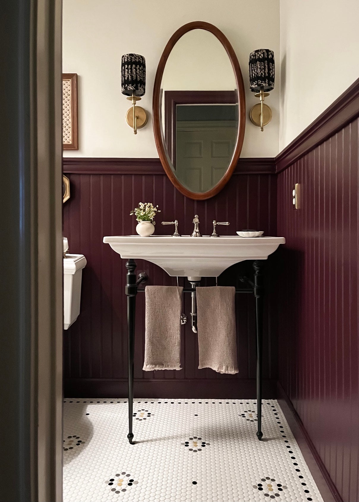 A bathroom with an antique sink and a unique penny round patterned floor.
