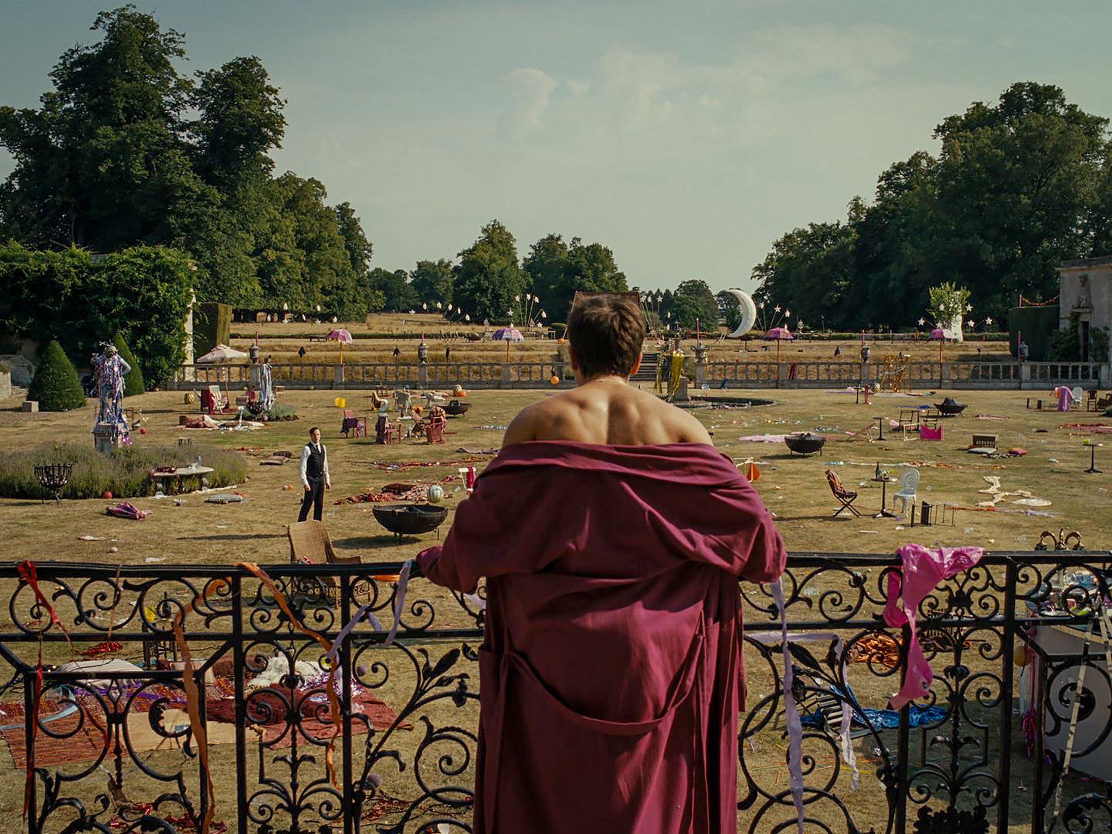 Jacob Elordi in Saltburn film standing in robe looking at party aftermath 