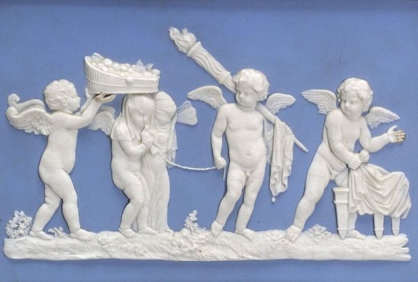 A ceramic white plaque with 19th century cherubs.