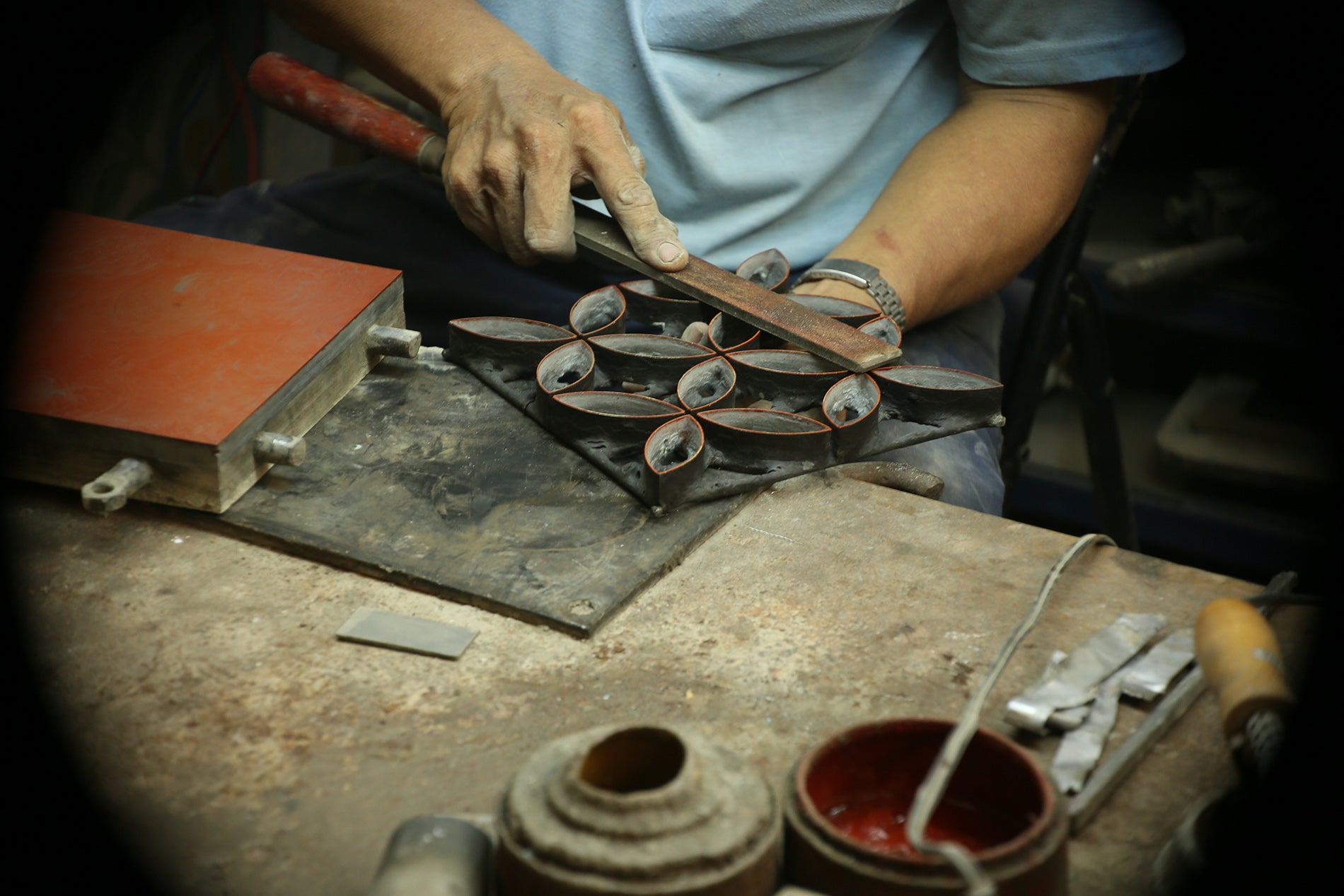 An artisan holding a metal mold.