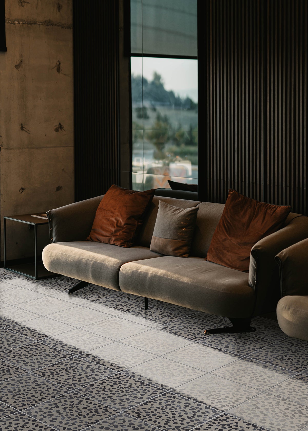 Black, grey and white cement tiles and a couch.