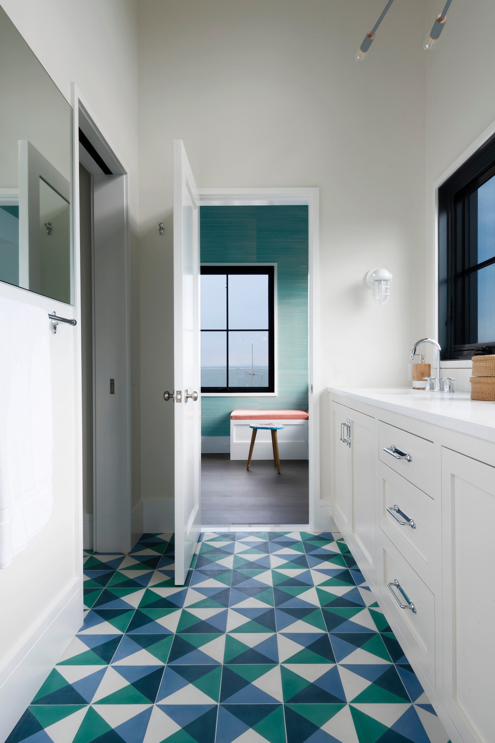 A modern apartment with a bright blue, green and white geometric cement tile floor.