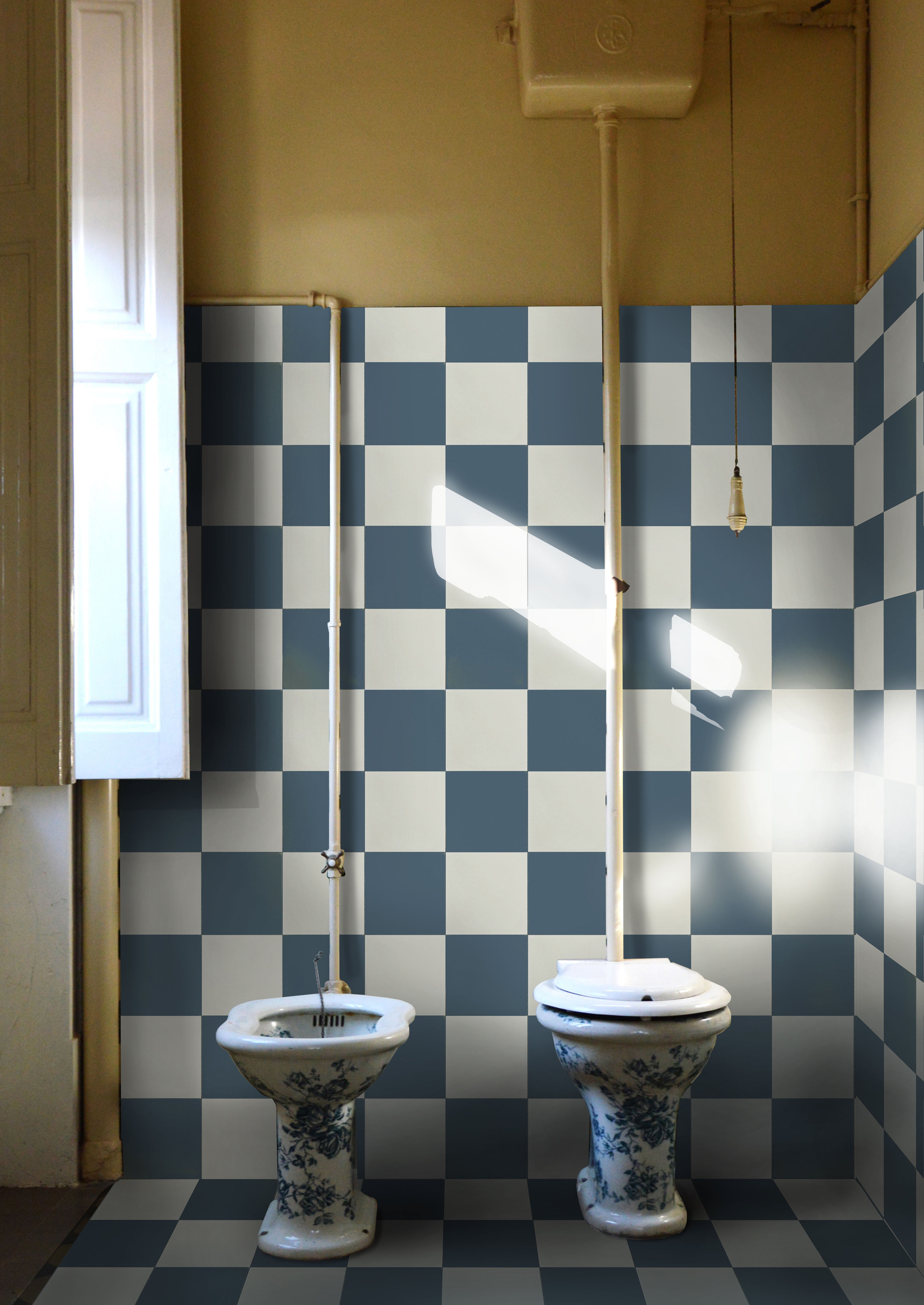 Square cement tiles in medium blue and white behind a toilet and bidet.