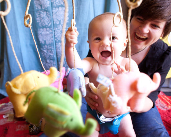 baby and mom playing with amani kikoy elephant mobile