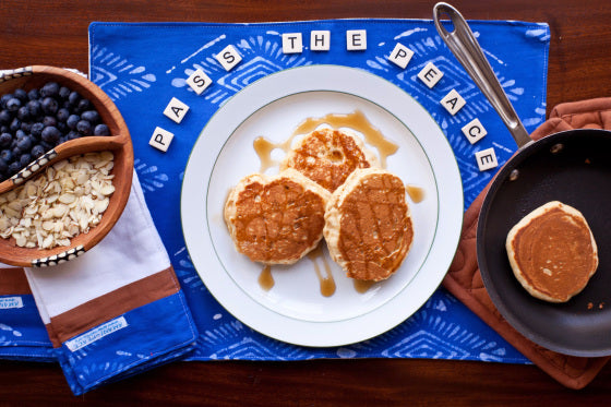 flat lay on an amani placemat with pancakes, oatmeal, and blueberries