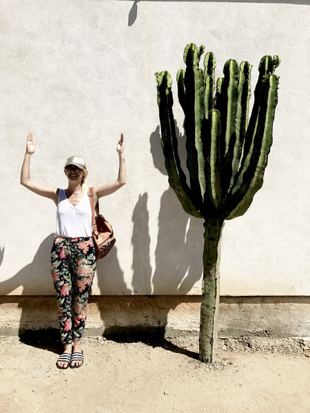 Alyssa standing in a cactus pose in front of a large cactus in Old Town. 