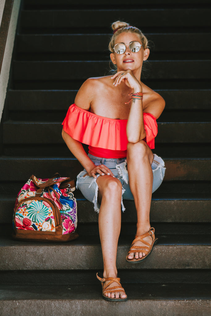 Alyssa wearing a ruffled pink swimsuit in Free People sunglasses and denim cutoffs