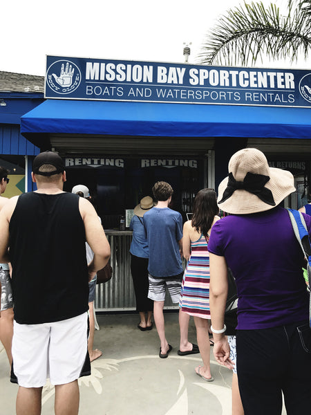 A photo of Mission Bay Sportscenter from the view of someone waiting in line for a paddle board rental