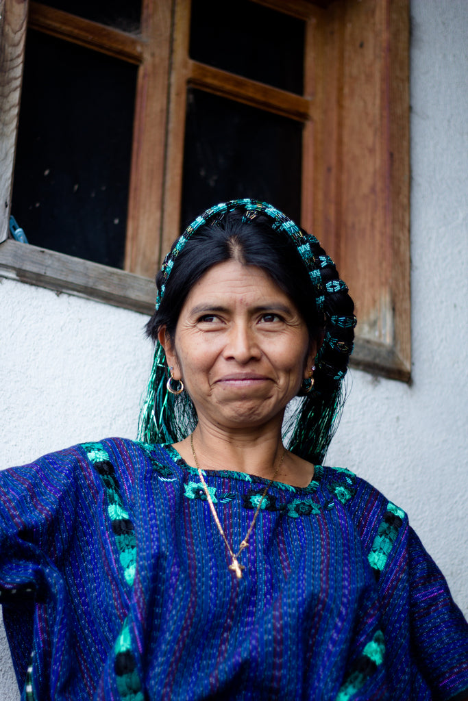 Maria standing at the door of her home in San Antonio, Guatemala to greet visitors. 