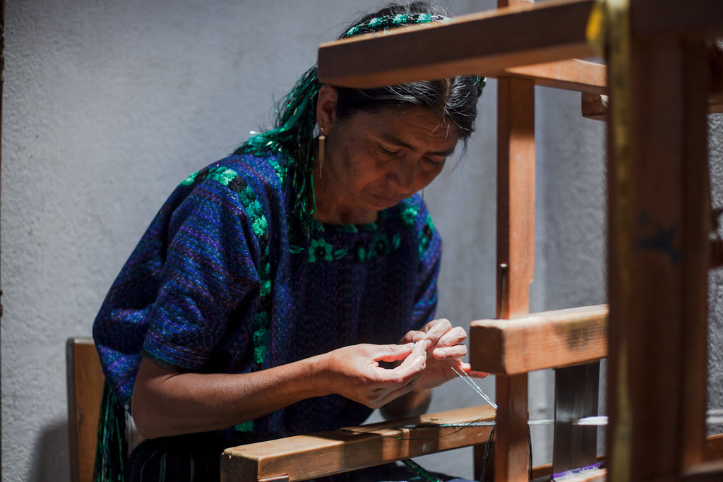 Maria quickly moves her fingers to create the tocoyal on the machine, home workshop weaving, fashion workers rights in Guatemala, ethically woven textiles from Guatemala, traditional maya attire