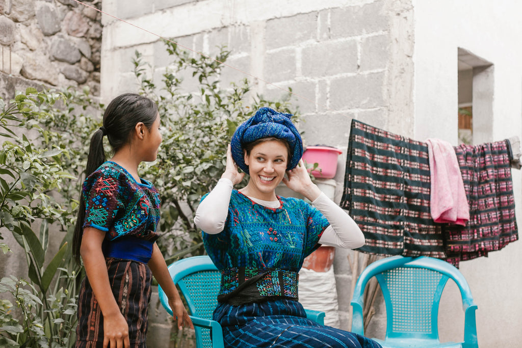 She Is Not Lost blogger Carina otero smiles as she feels the large blue headwrap traditionally worn in Santa Catarina Palopó, best experiences in Guatemala, crazy things to do in Guatemala, travel ethically in guatemala, ethical travel blogs, ethical travel bloggers