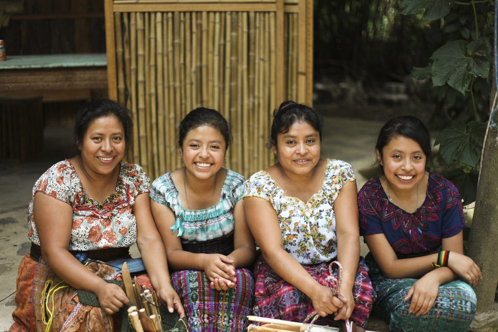 Maya smile in workshop with their lanzaderas and fabrics, maya artisans, tz'utujuil natural dyeing process, naturally died textiles shipped to the US