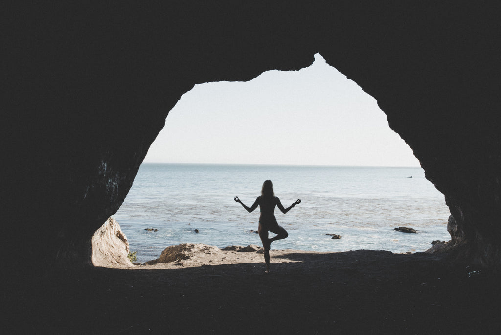 A view of the ocean from the inside of a cave at Pismo Beach, California as Alyssa is in a yoga pose. 