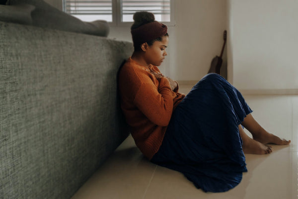 A worried woman sitting on the floor