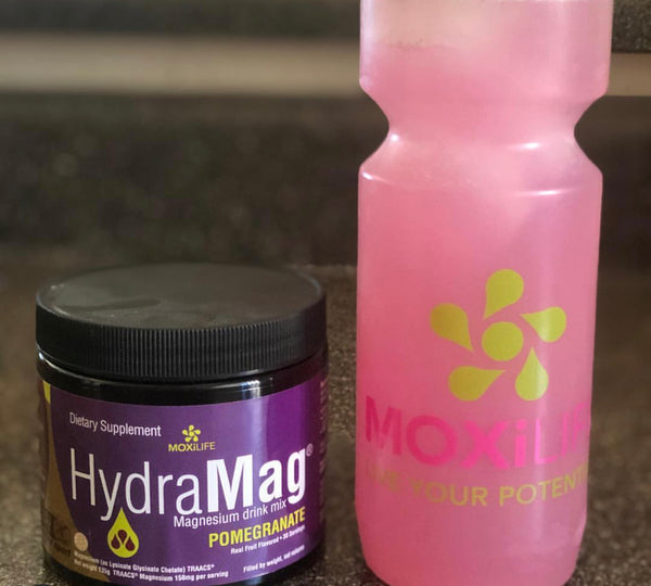 Hydramag 30 svg Canister sitting next to Moxilife water bottle with pink pomegranate hydramag inside