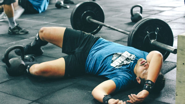 dehydrated athlete laying down on gym floor