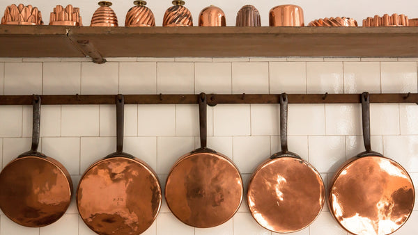 Copper pots and pans hanging from wall