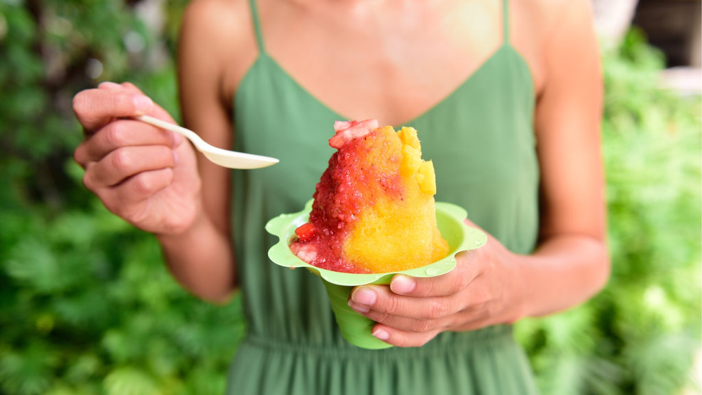 woman in green dress holding shave ice bowl