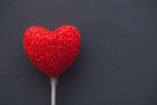 red Heart shaped lollipop on a stick