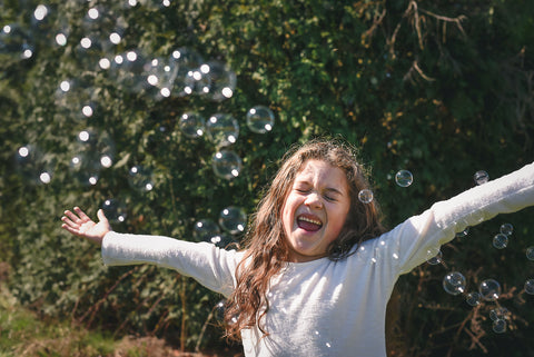 young girl playing with delight and BUBBLES!