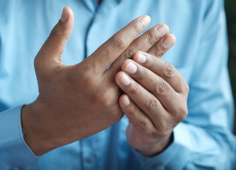 Man rubbing pain in hand and fingers