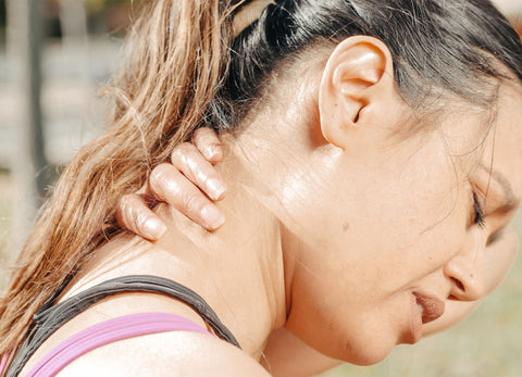 Woman athlete rubbing stiff neck pain