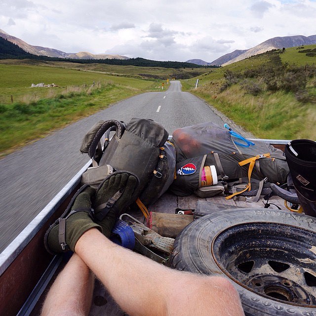 POV perspective of backpacking gear riding in the back of a truck wearing Bedrock Sandals and socks