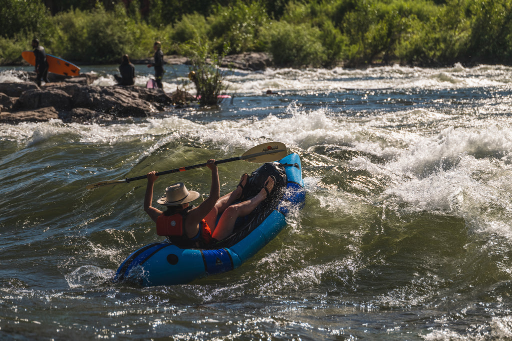 Person rafting over wave in Missoula wearing Bedrock sandals