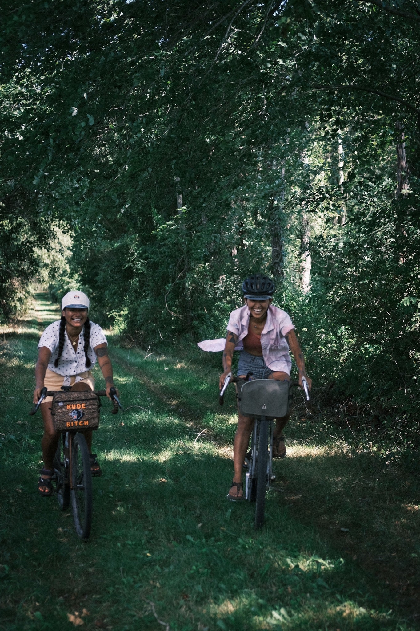 Two friends riding their bikes smiling wearing sandals