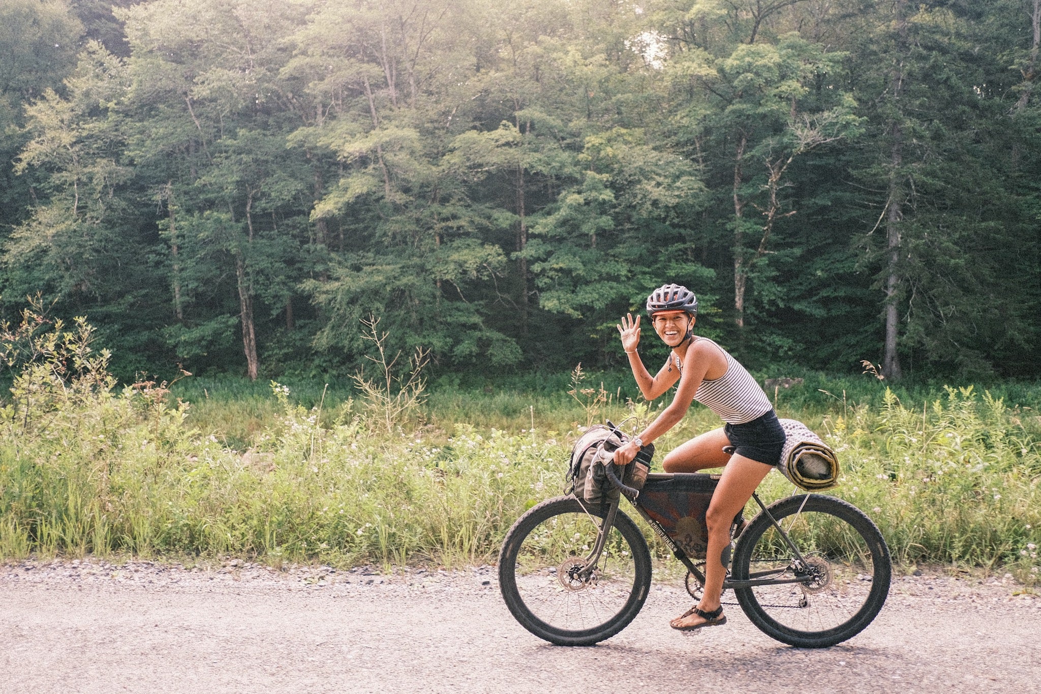 A person waving while riding their bike