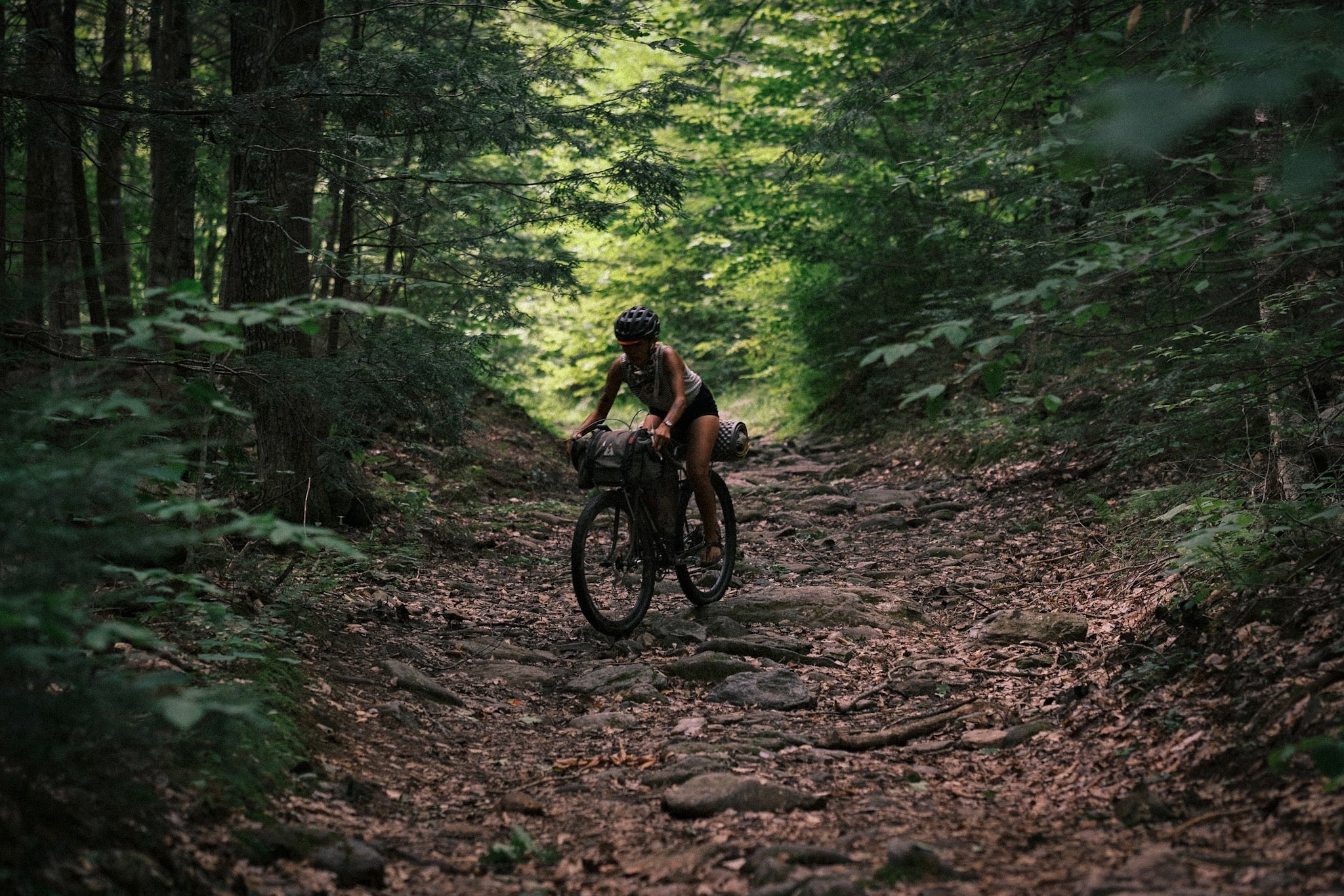 A person bike riding rocky new england trails 