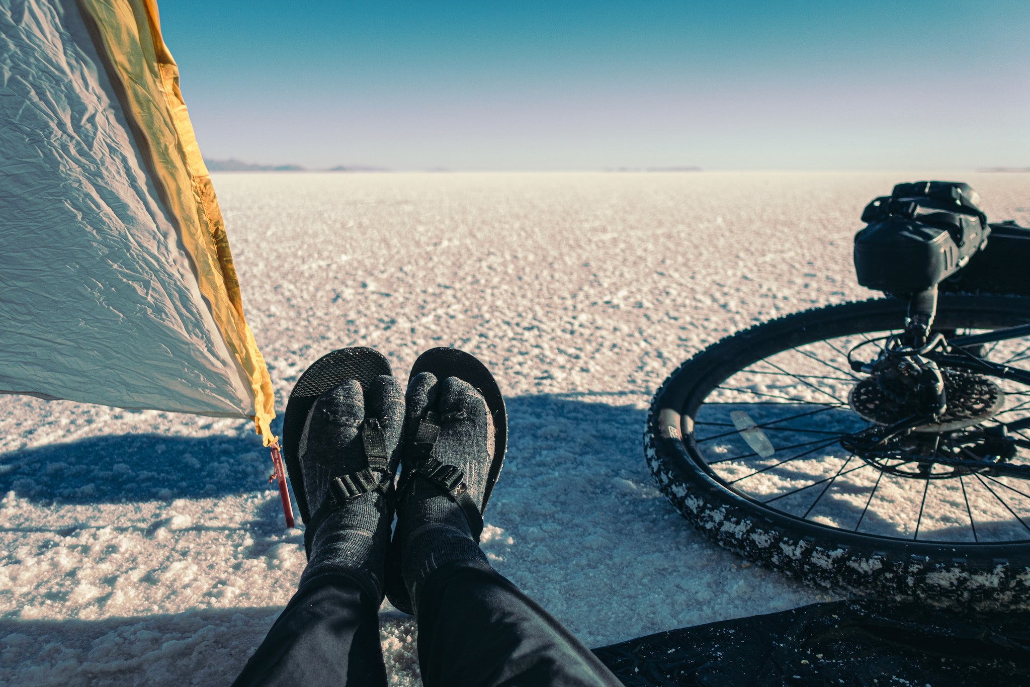 Bicyclist wearing Bedrock Sandals on salt flat