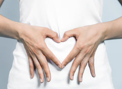 hand forming a heart over stomach