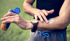 man applying sunscreen to arm