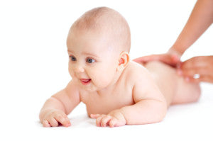 baby lying isolated getting massage from mother's hands