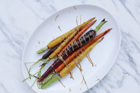 Roasted with carrots on a white plate drizzled with JEM Organics nut butter