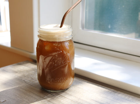 Iced coffee in a glass jar on a counter