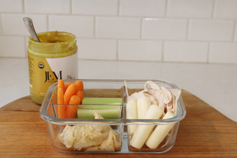 Tupperware filled with carrots, celery, turkey, cheese and nut butter 