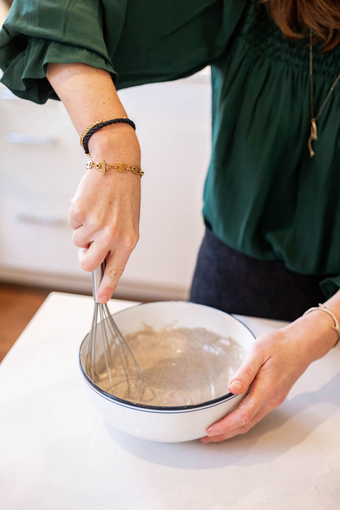 making smoked salmon blini wearing sailor stack of bracelets for women