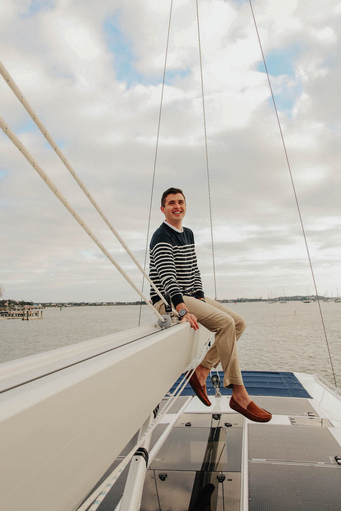 Paul Landry wearing brooks brothers on the boom of a sailing yacht