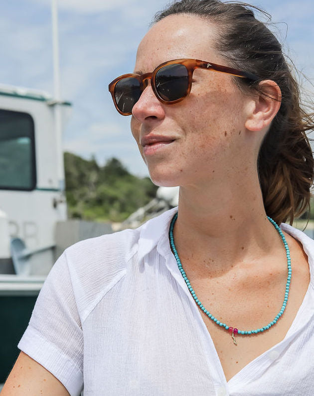 sailormade rayminder uv awareness necklace in turquoise worn outside on boat