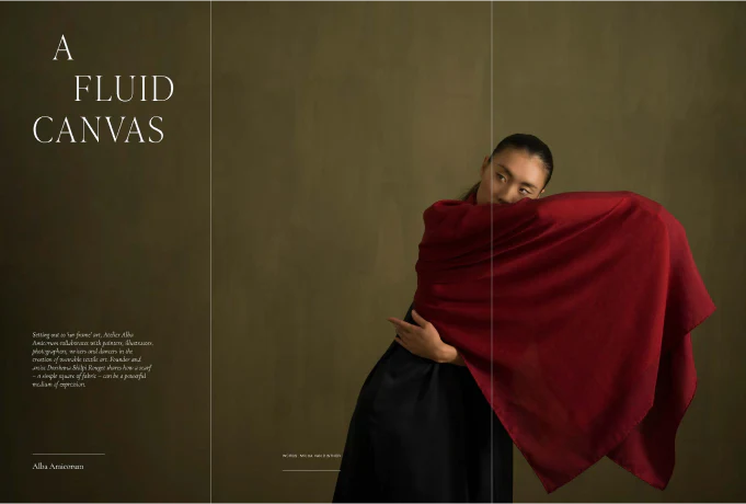 An image of the title page of the Article below - A Fluid Canvas, a woman in a red color block albaamicorum scarf posing before an olive colored wall